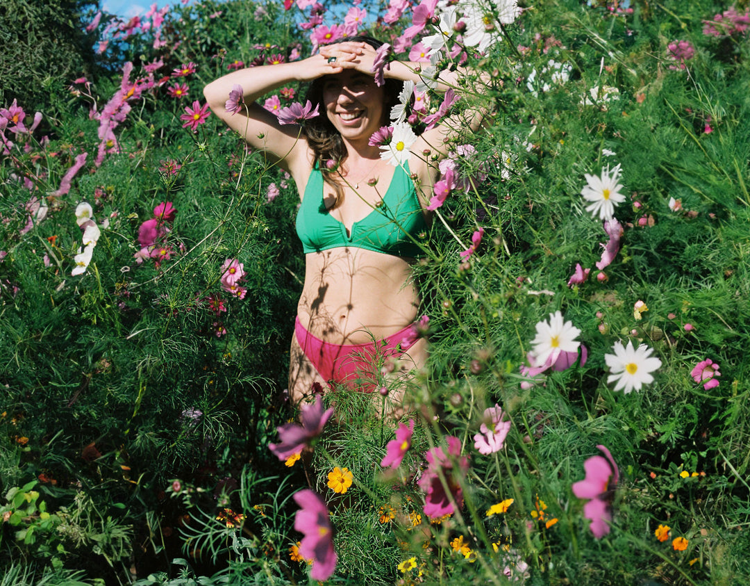 Sarah Bra in Poise Green and Whitney Bikini in Bohemian Pink amongst wildflowers