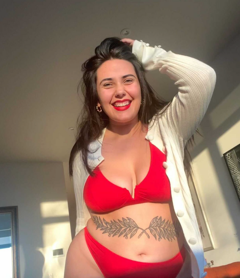 customer wearing Belle bra in shield black, lying down with baby, breastfeeding