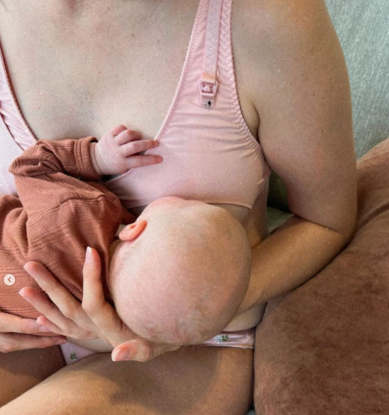 customer breastfeeding baby sitting down, wearing rosy belle bra
