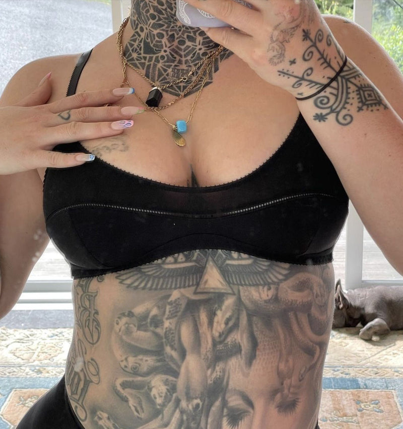 customer wearing belle maternity bra in shield, baby snuggling lying down