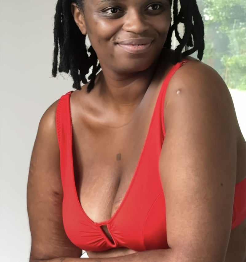customer wearing Belle bra in shield black, lying down with baby, breastfeeding