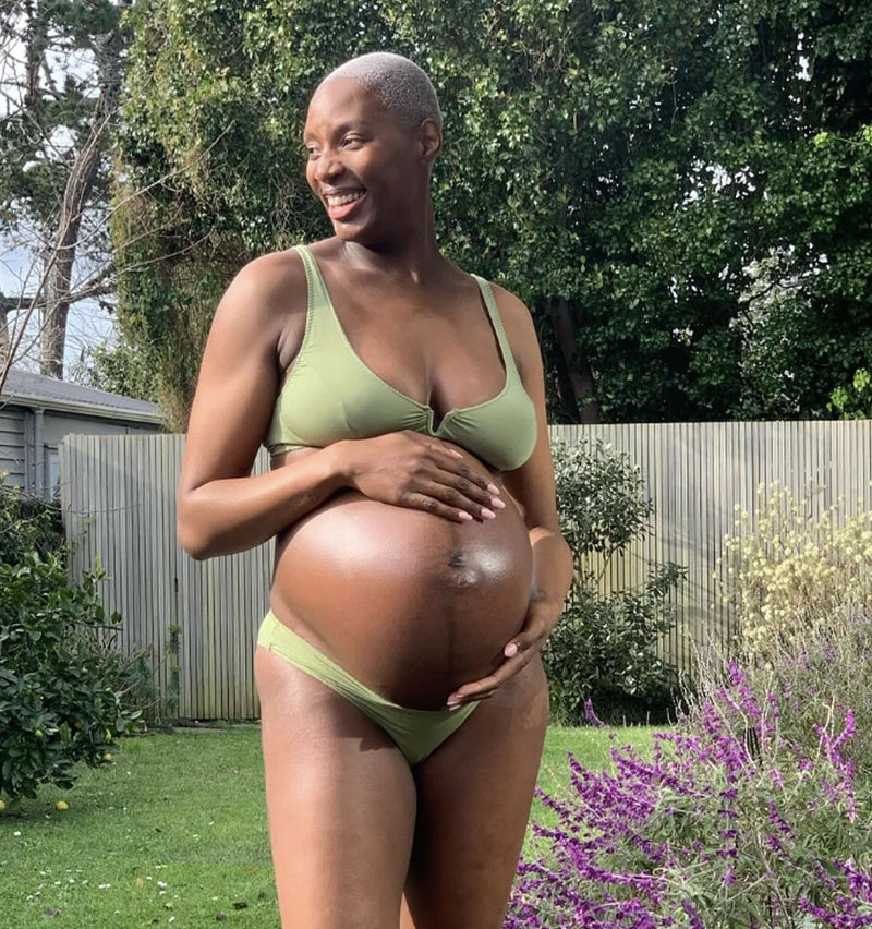 customer breastfeeding baby sitting down, wearing rosy belle bra